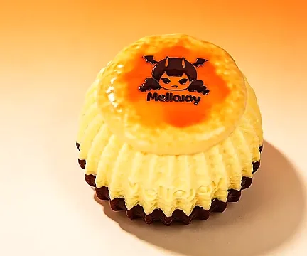 メロジョイの新作プリンケーキ。天面がカラメル色で、中央のロゴは悪魔の角とコウモリの羽